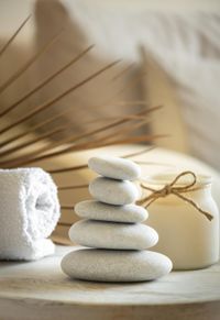 sea-stones-balance-on-wooden-table-candle-and-towel-spa-and-relax-concept-free-space-for-text-selective-focus-banner